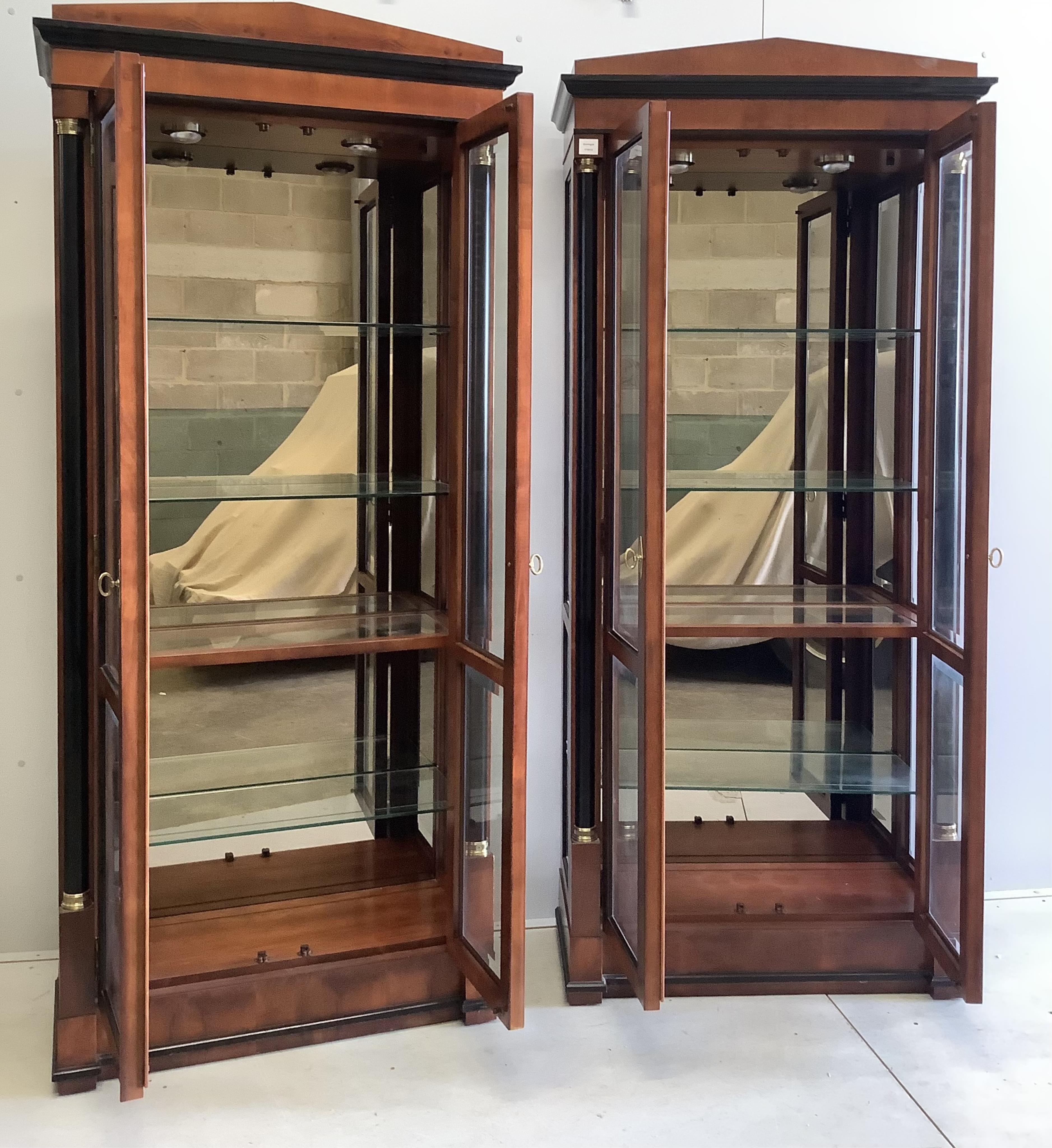 A pair of French Empire style mahogany and ebonised two door display cabinets, width 92cm, depth 42cm, height 210cm. Condition - good